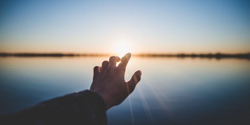 Beitrag zur Wirkung von Meditation auf Resilienz und Gesundheit - Hand vor Sonnenaufgang